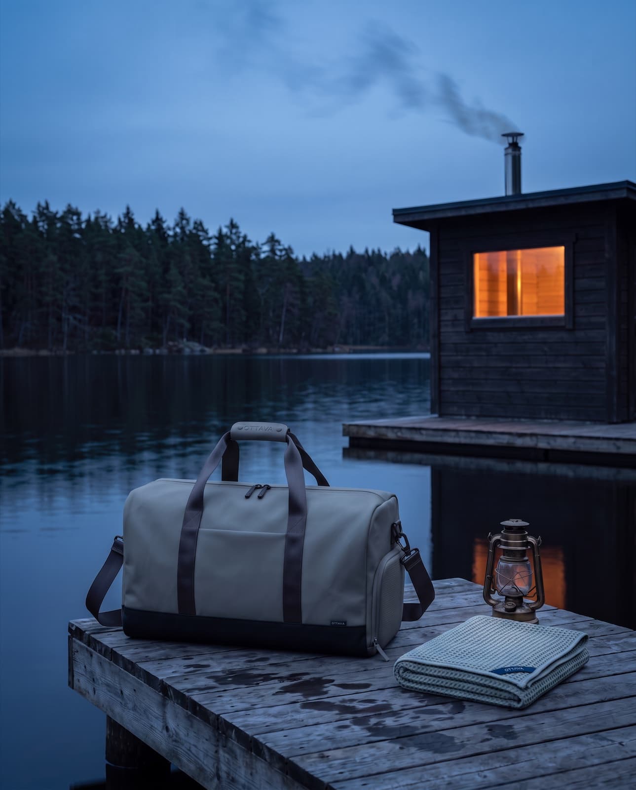Duffel 50 on a lakeside sauna jetty at blue hour