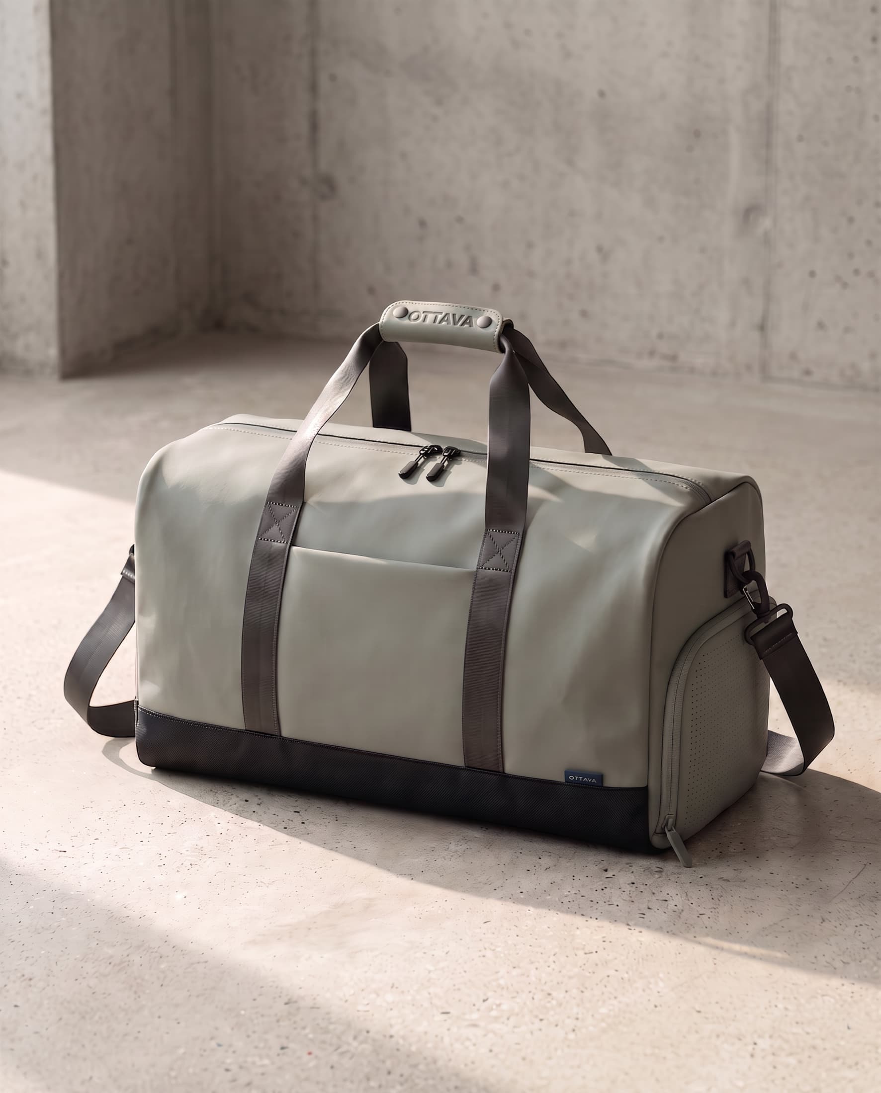 OTTAVA Duffel 50 in Fog Sage on a concrete floor in morning light