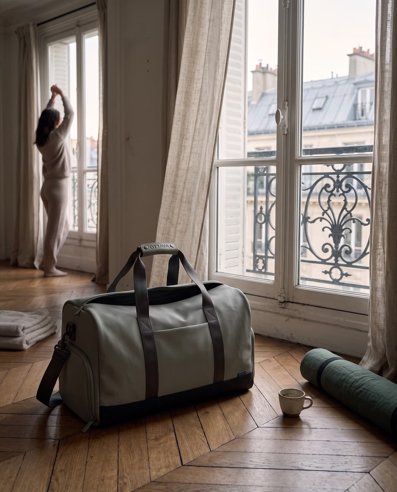 Duffel 50 on a herringbone floor by tall Paris windows at dawn